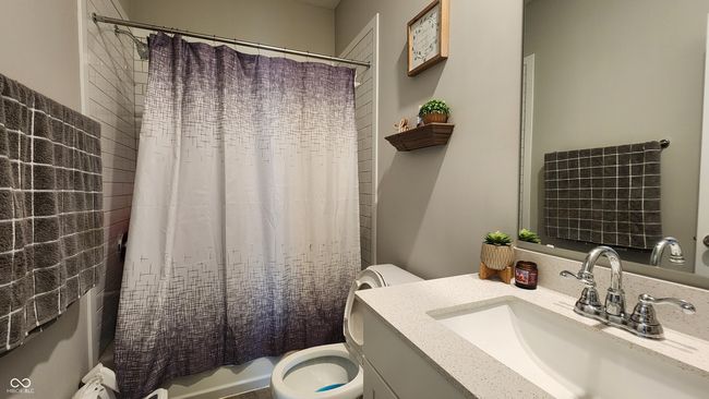 full bathroom in main floor featuring vanity and shower / bath combo with shower curtain | Image 11