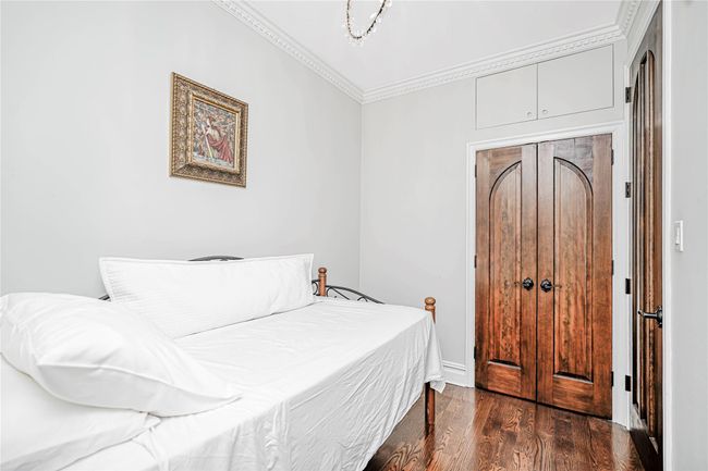 Bedroom with ornamental molding and dark wood-style floors | Image 26