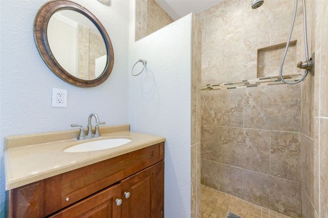Bathroom featuring vanity, a tile shower, and a textured wall | Image 31