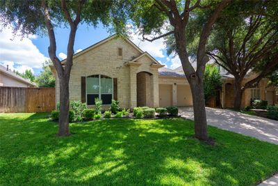 This view of the front showcases trees & landscaping | Image 2