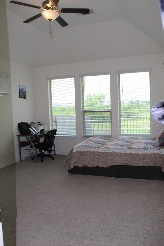 Carpeted bedroom featuring lofted ceiling, ceiling fan, and baseboards | Image 5