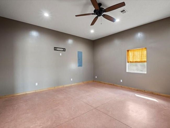 Unfurnished room with electric panel, visible vents, recessed lighting, finished concrete floors, and ceiling fan | Image 61
