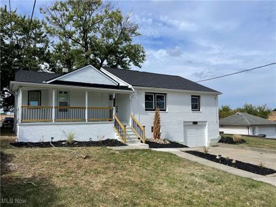 View of front of property featuring a porch, a garage, and a front lawn | Image 3