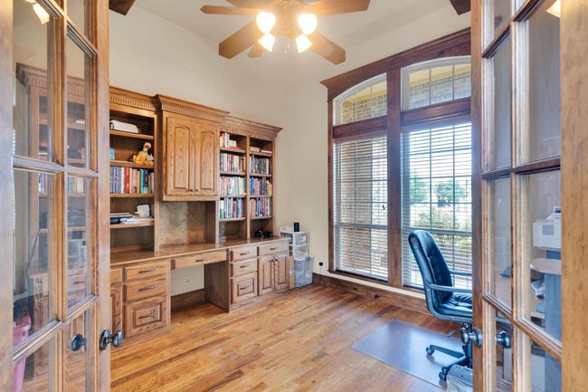 Office space featuring built in study area, a ceiling fan, and light wood-style floors, built in cabinets | Image 12