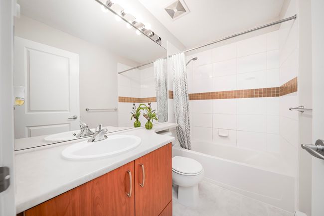 Full bathroom featuring visible vents, toilet, shower / bathtub combination with curtain, vanity, and tile patterned flooring | Image 28