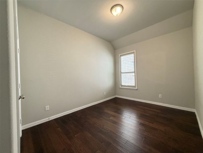 Empty room featuring baseboards, dark wood-style floors, and vaulted ceiling | Image 14