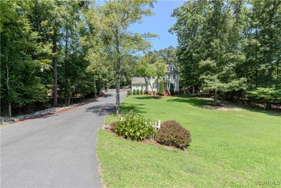 Situated on over an acre lot, the neatly manicured yard, the beautiful plantings, and the large asphalt driveway are just a few of this home's many features! | Image 2