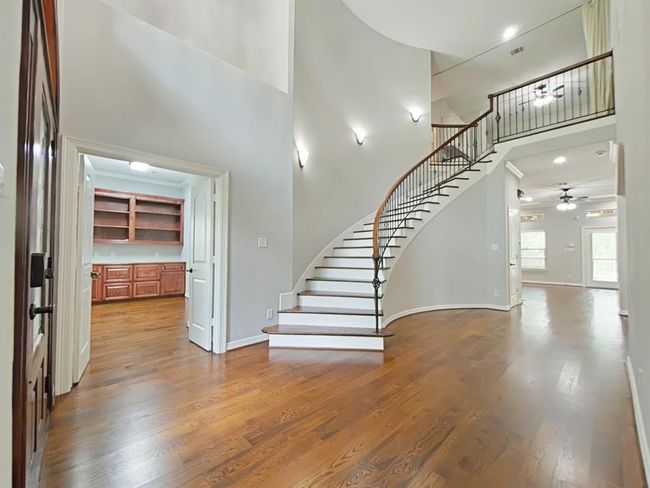Welcome home to high ceilings, elegant curved stairs and rich wood flooring, creating a stunning entryway. | Image 4