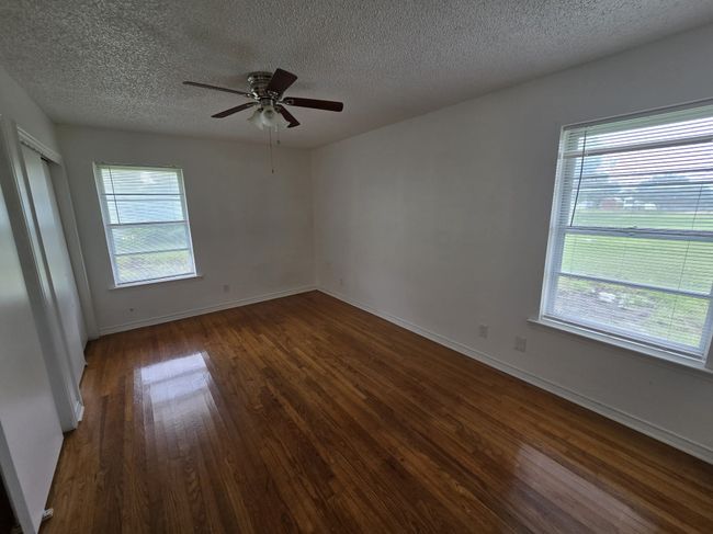 Unfurnished room with dark wood-type flooring, a textured ceiling, and a ceiling fan | Image 7