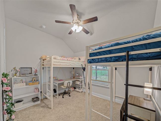 Carpeted bedroom featuring lofted ceiling, a ceiling fan, and a desk | Image 24