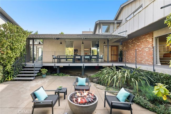 Open the gate and a gorgeous courtyard with outdoor seating areas reveals itself and makes all feel welcome upon arrival. | Image 5
