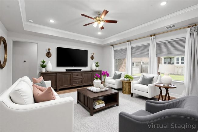 Living area with crown molding, a ceiling fan, a raised ceiling, and light wood-style floors | Image 5