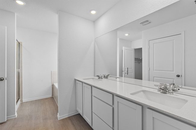 Full bath with double vanity, wood finished floors, a garden tub, an enclosed shower, and recessed lighting | Image 13