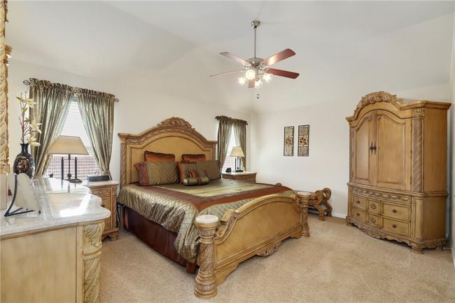 Bedroom featuring light carpet, ceiling fan, and baseboards | Image 12