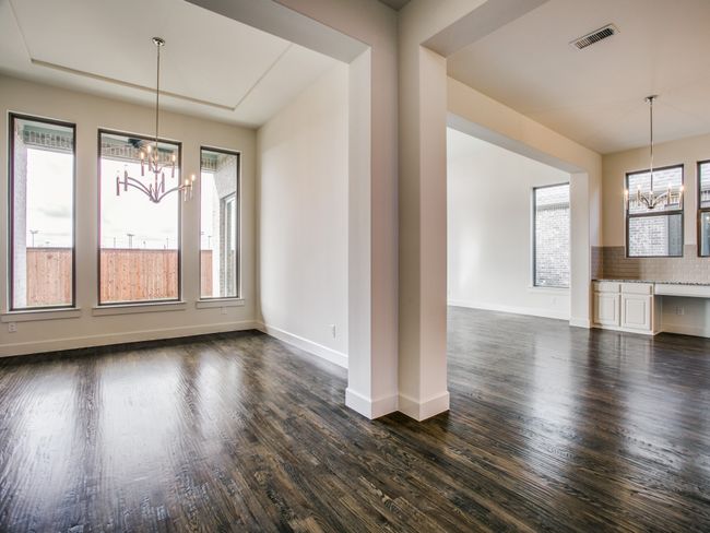 Unfurnished dining area featuring a chandelier and dark wood-style flooring | Image 6