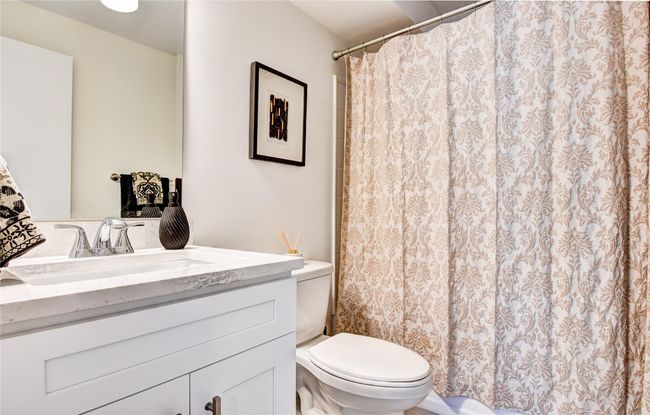 Bathroom featuring a shower with curtain, toilet, and vanity | Image 18
