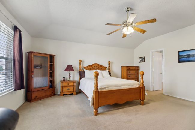 Carpeted bedroom with vaulted ceiling and ceiling fan | Image 17