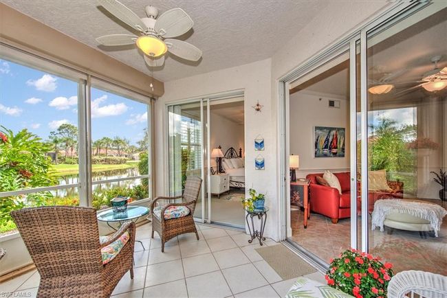 Sunroom with a ceiling fan, a water view, and visible vents | Image 25