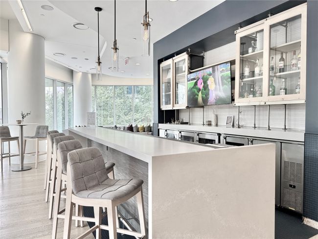 Bar area with plenty of natural light, decorative light fixtures, light wood-style floors, and recessed lighting | Image 36