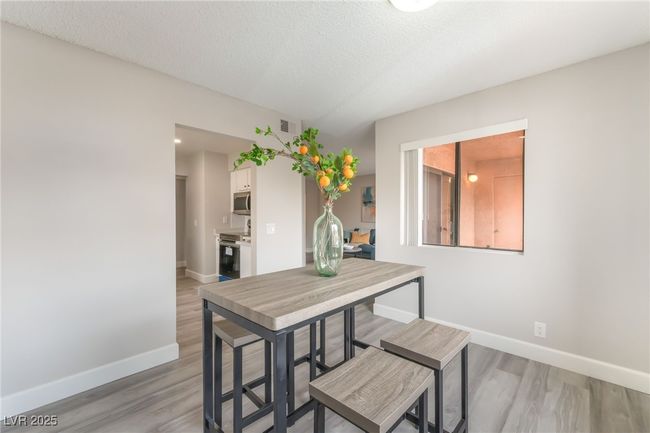 Dining area with light wood-type flooring and a textured ceiling | Image 8