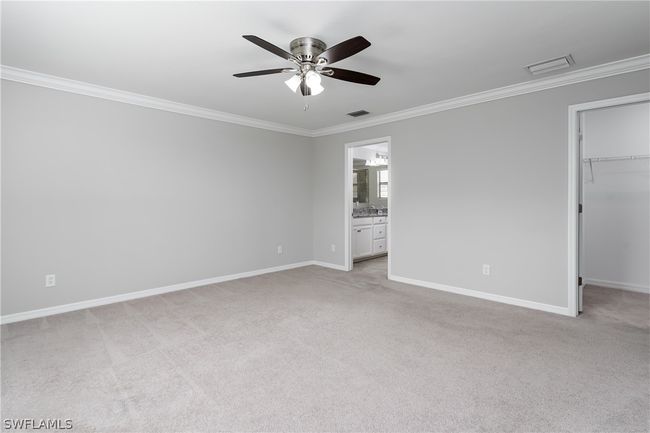 Unfurnished bedroom featuring ceiling fan, a closet, light colored carpet, and a spacious closet | Image 23