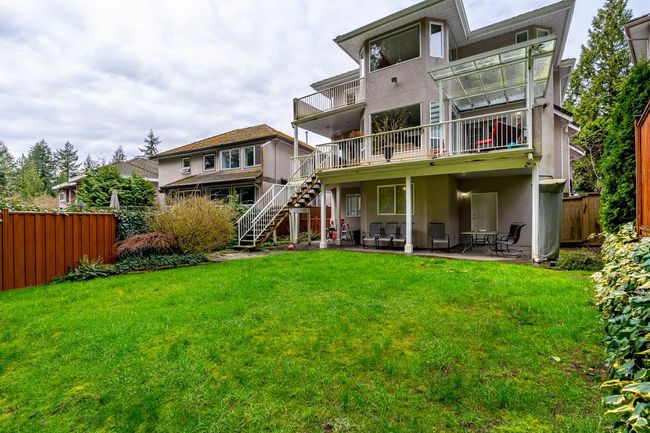 Back of house featuring stucco siding, stairway, a patio, fence, and a lawn | Image 5