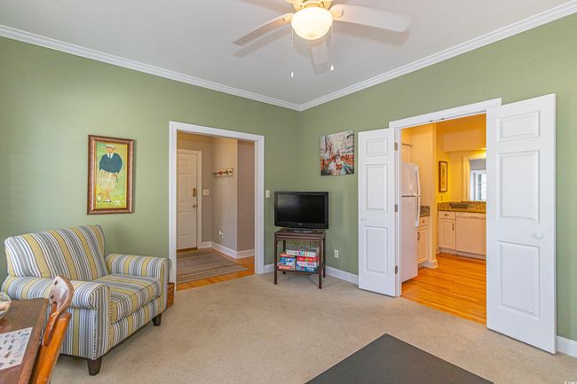 Sitting room featuring a ceiling fan, ornamental molding, baseboards, and light colored carpet | Image 30