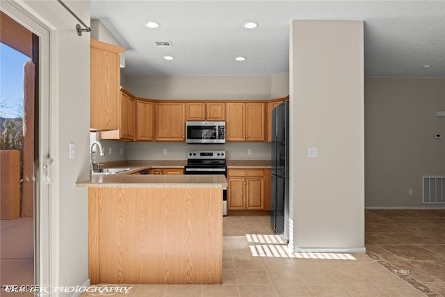 Kitchen featuring visible vents, a peninsula, recessed lighting, appliances with stainless steel finishes, and a sink | Image 10