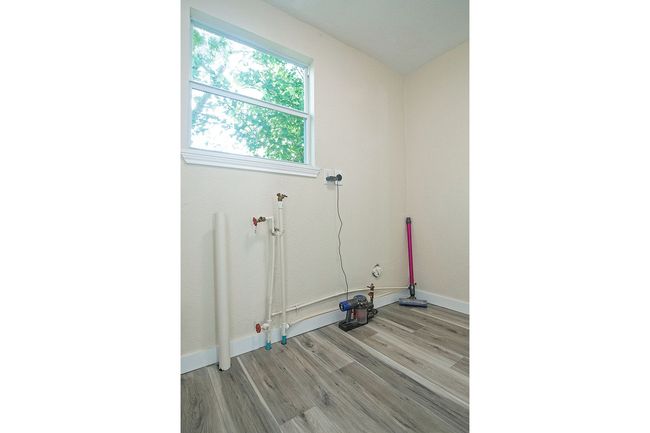 Laundry area featuring light wood finished floors and baseboards | Image 18