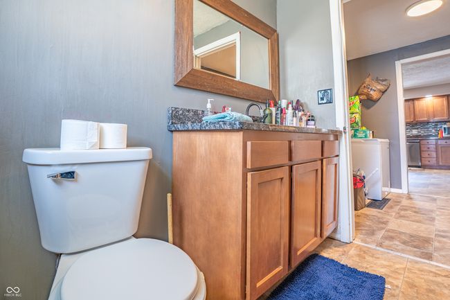 bathroom with backsplash, washer / dryer, toilet, and vanity | Image 13