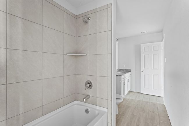 Full bathroom featuring toilet, vanity, and tiled shower / bath | Image 8