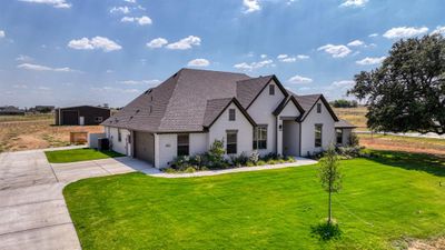 View of front of property featuring a garage and a front lawn with sprinkler system | Image 1