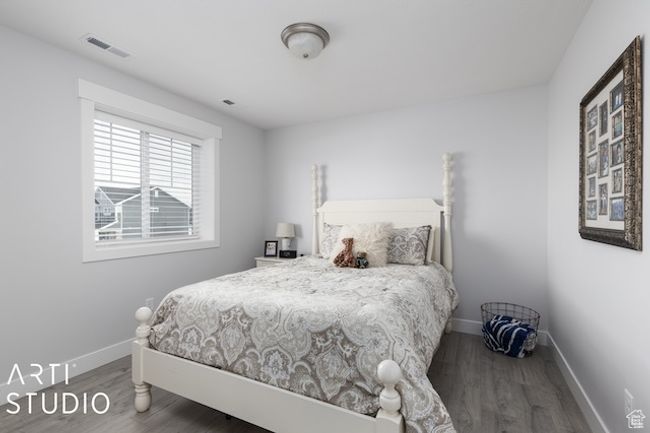 Bedroom with visible vents, baseboards, and wood finished floors | Image 26