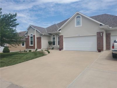 Ranch-style house with a front lawn and a garage | Image 2