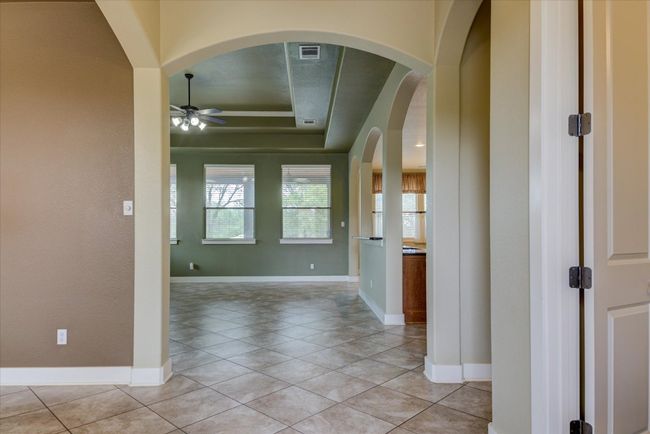 Front entry with light tile patterned floors, a raised ceiling and arches | Image 4