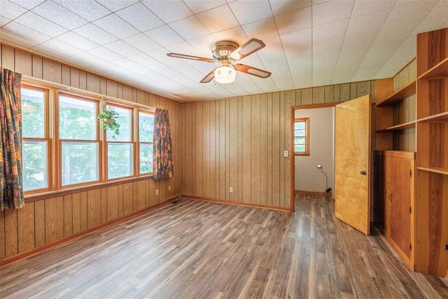 Unfurnished living room featuring carpet floors, a sink, baseboards, and a ceiling fan | Image 4