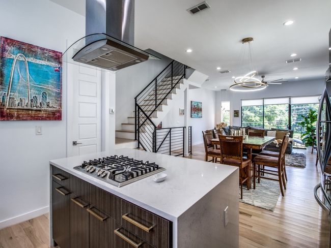 Kitchen featuring island range hood, stainless steel gas cooktop, light wood finished floors, recessed lighting, and light countertops | Image 14
