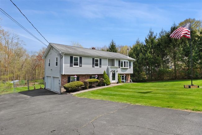 Bi-level home with driveway, brick siding, a front lawn, and a garage | Image 36