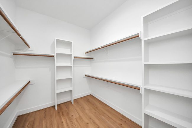 The expansive walk-in closet has built-in shelving and plenty of storage space. | Image 20