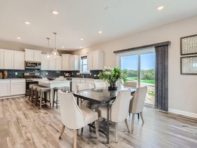 (Photo of a decorated model, actual homes finishes will vary) Soaked in natural sunlight, the homes eat-in dining room has ample space for a dining table located in the heart of the home. | Image 3