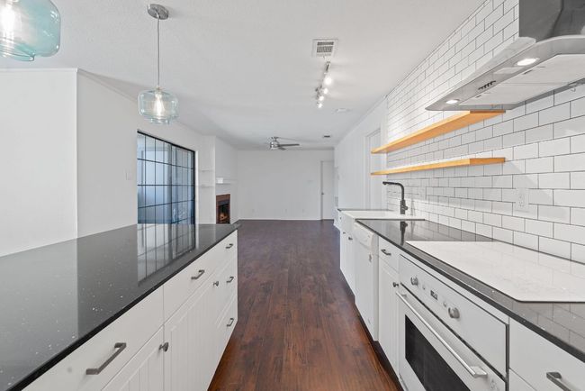 The kitchen is a chef's dream with quartz countertops, chic appliances, and subway tile backsplash. | Image 4