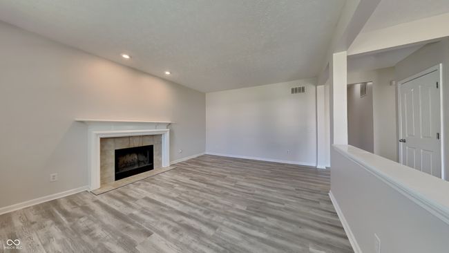 unfurnished living room featuring recessed lighting, wood finished floors, baseboards, and a textured ceiling | Image 5