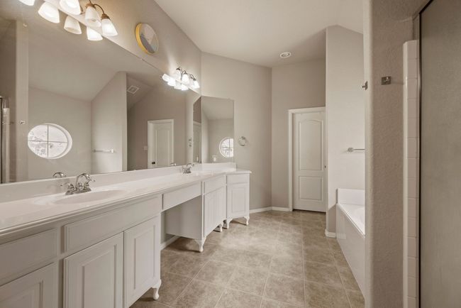 Bathroom with a bath, a sink, tile patterned flooring, and double vanity | Image 21