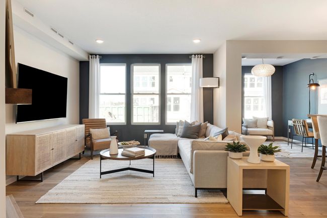 Soaring windows drench the living room in natural light! Photo of model home. | Image 5