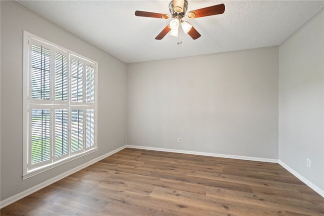 Spare room featuring baseboards, wood finished floors, and ceiling fan | Image 5