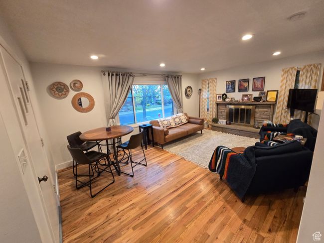 Living area featuring baseboards, recessed lighting, wood finished floors, and a fireplace | Image 9