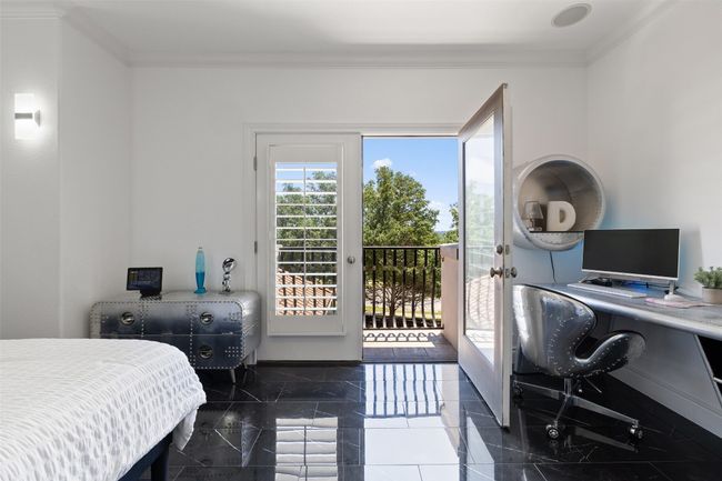 Bedroom featuring access to exterior, crown molding, an office area, granite tiled floors, and baseboards | Image 23