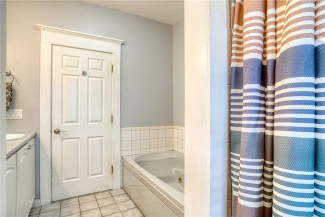 Bathroom featuring tile patterned floors, a bathing tub, and vanity | Image 12