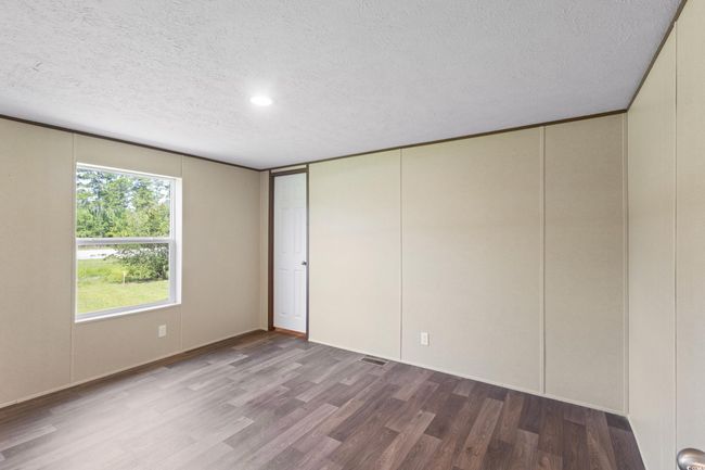 Unfurnished bedroom with a textured ceiling, wood finished floors, and recessed lighting | Image 37