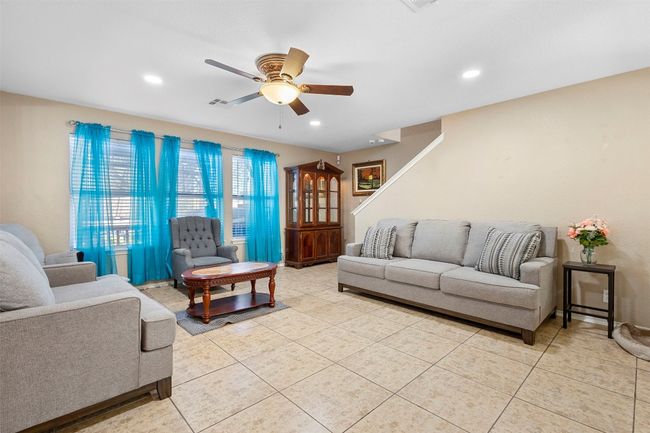 Living room with light tile patterned floors, recessed lighting, stairway, and ceiling fan | Image 9